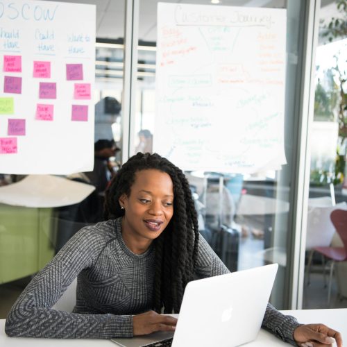 Confident woman working on laptop at modern indoor office desk.